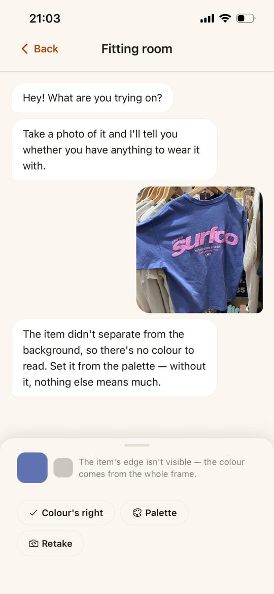 Ecru’s fitting-room chat: a photo of a blue T-shirt on a shop rail, and under it the app saying the item didn’t separate from the background so there is no colour to read — offering to set it from the palette instead.